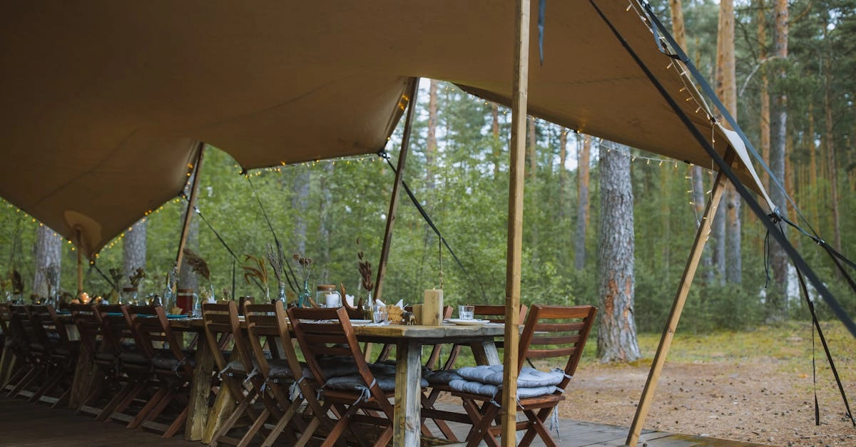 Турист с планшетом в палатке во время непогоды в горах